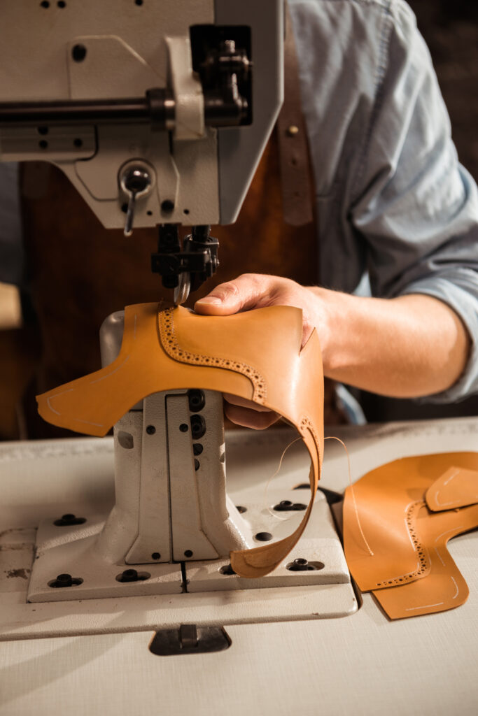 close up of a shoemaker using sewing machine close up of a shoemaker using sewing machine